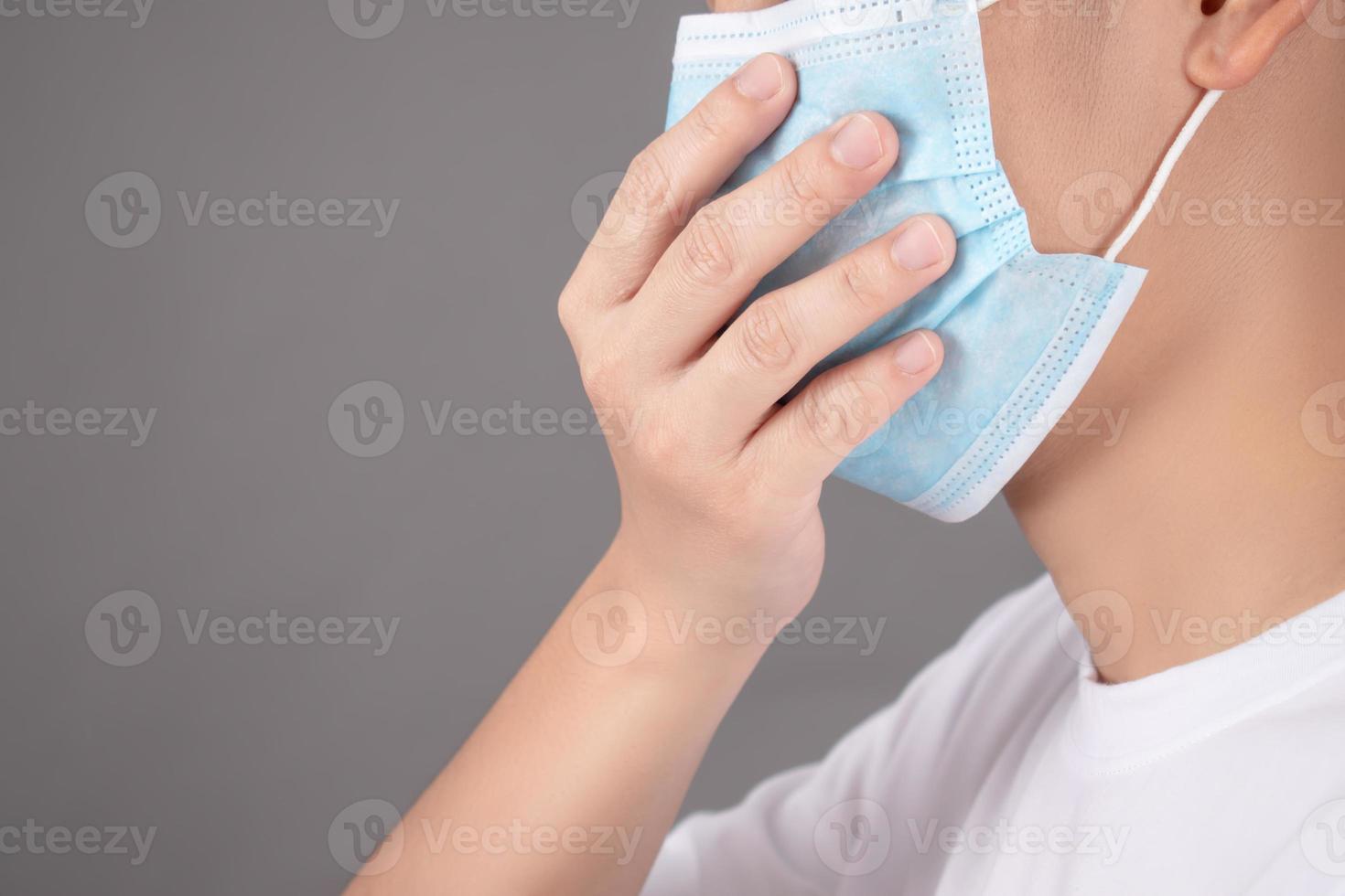 mensen hoesten, vervelend beschermend maskers Aan een grijs achtergrond in de studio foto