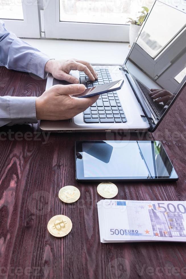 laptop met contant geld en bitcoin foto