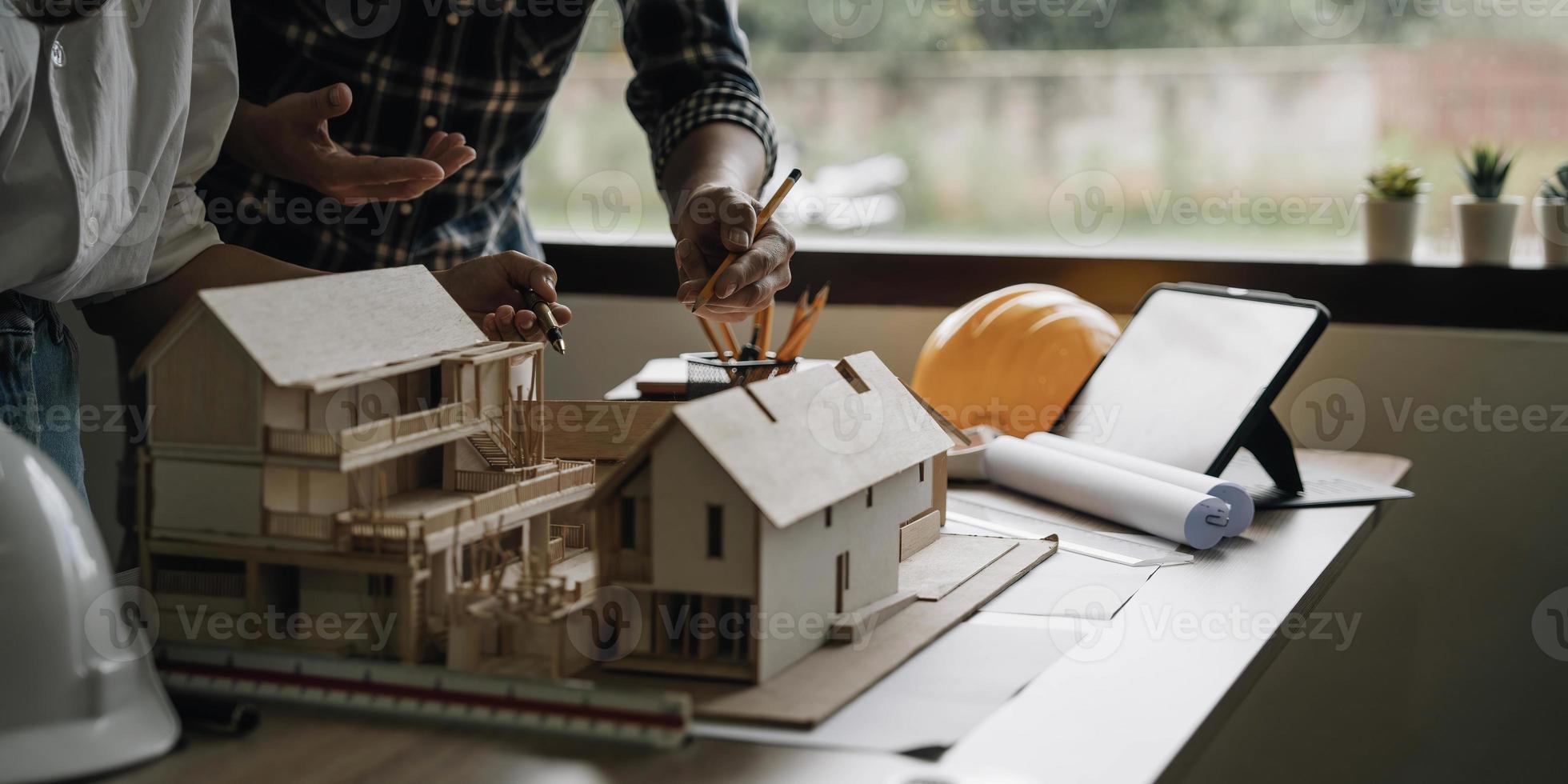 ingenieur teamwerkvergadering, tekenen werkend aan blauwdrukvergadering voor project werken met partner aan modelbouw en engineeringtools in werkplaats-, constructie- en structuurconcept. foto