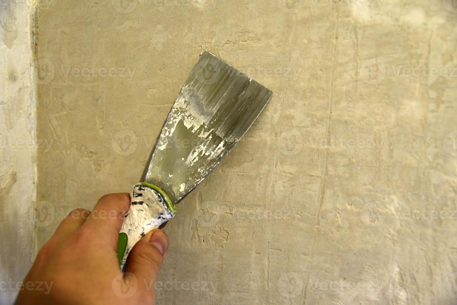 werk met een ijzer spatel wanneer bepleistering de muur met een cement oplossing. reparatie van de muur met een troffel met cement. foto