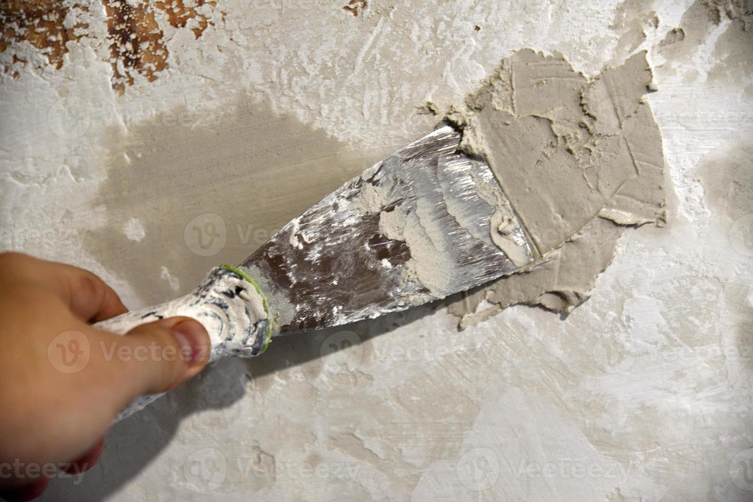 werk met een ijzer spatel wanneer bepleistering de muur met een cement oplossing. reparatie van de muur met een troffel met cement. foto