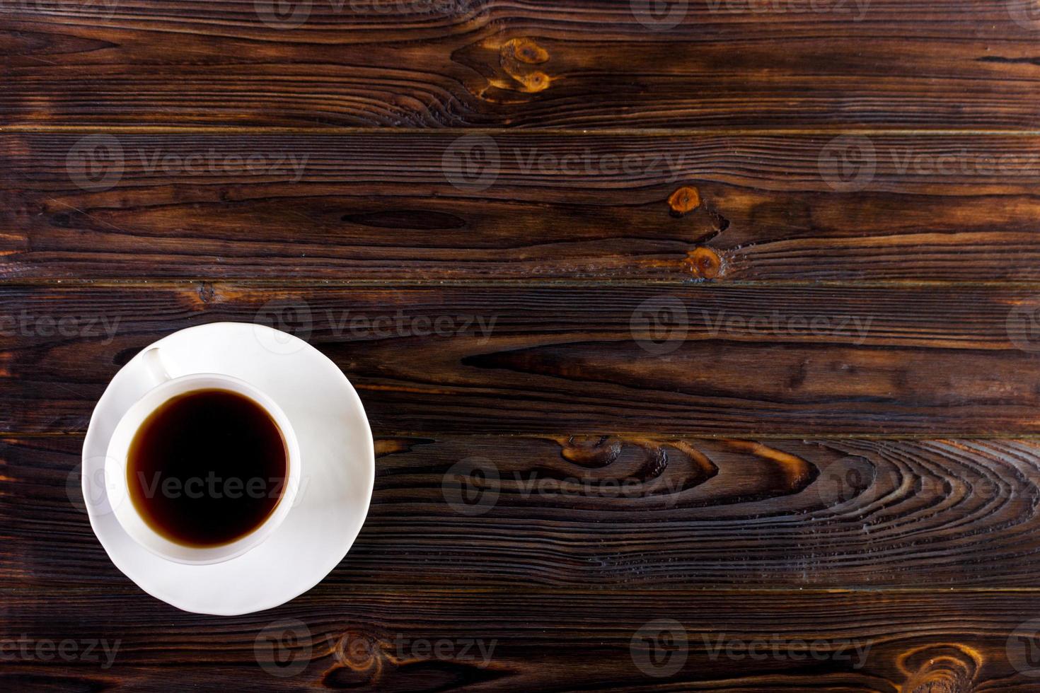 kop van koffie met schuim Aan houten tafel, top visie foto