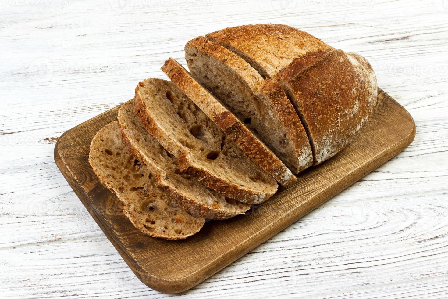 Frans gesneden brood Aan houten snijdend bord foto