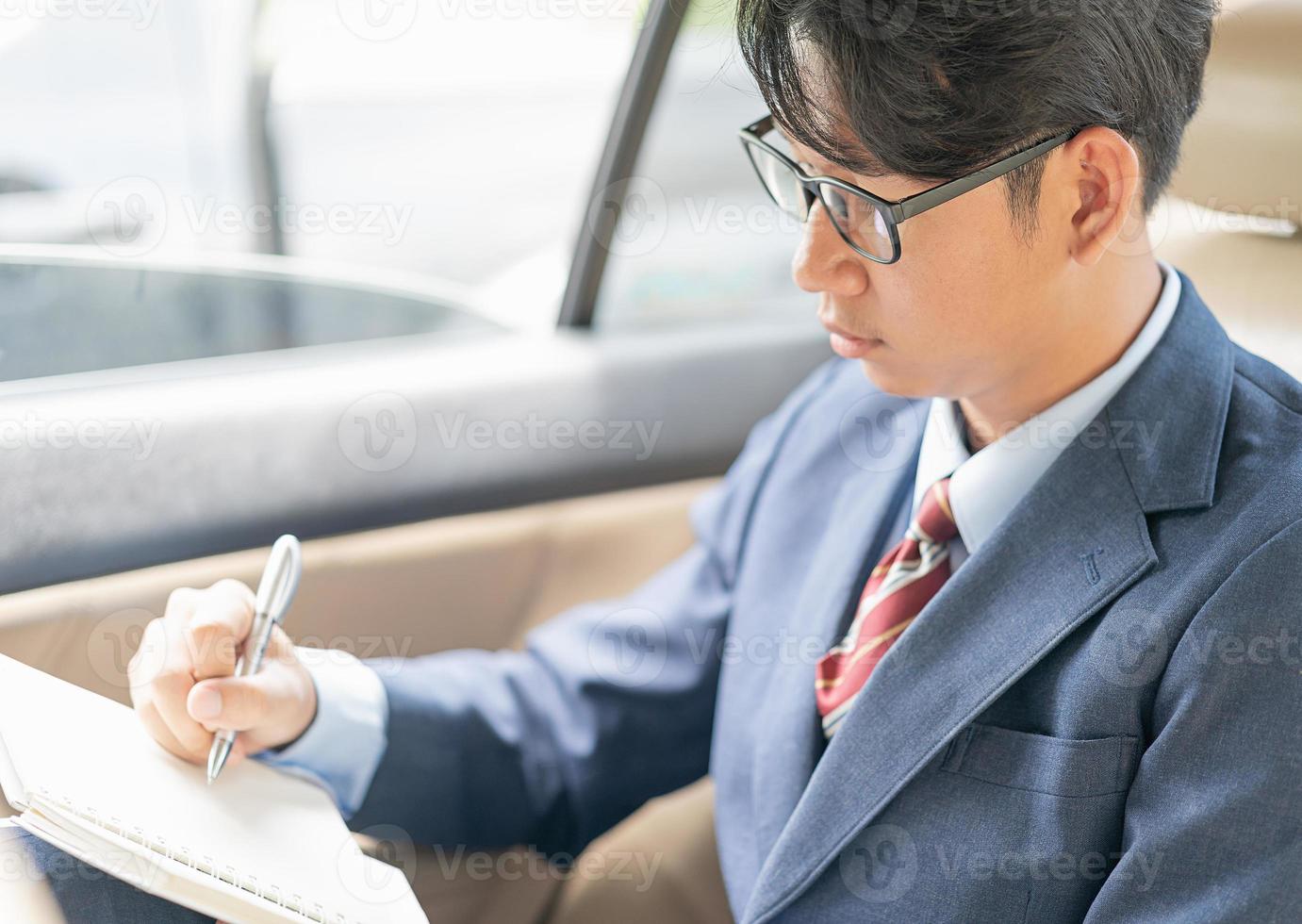 zakenman werken in de achterbank van een auto foto