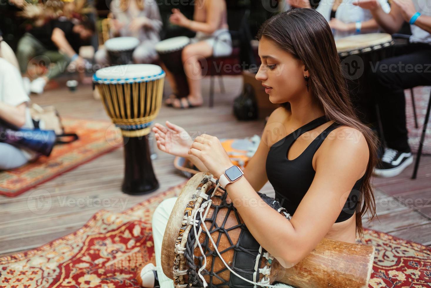 een jong mooi vrouw Toneelstukken een hand- trommel foto