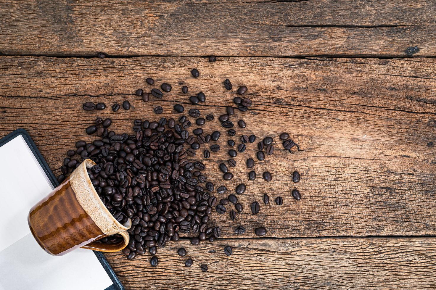 koffiebonen en notitieboekje op het bureau foto