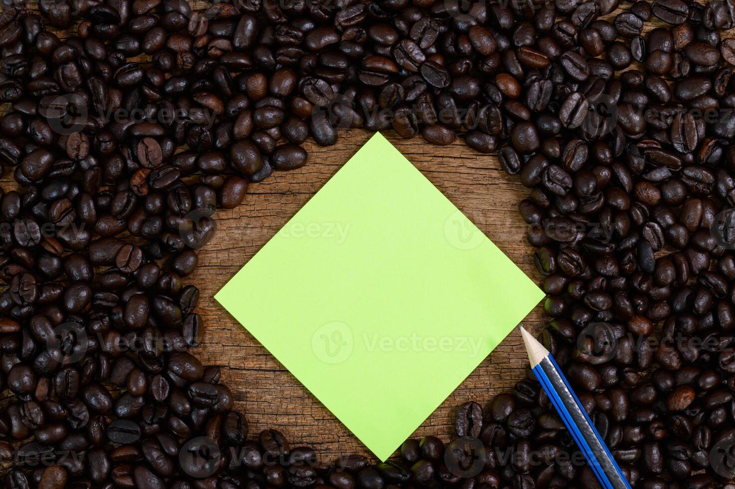 noteer papier, potlood en koffiebonen op het bureau foto