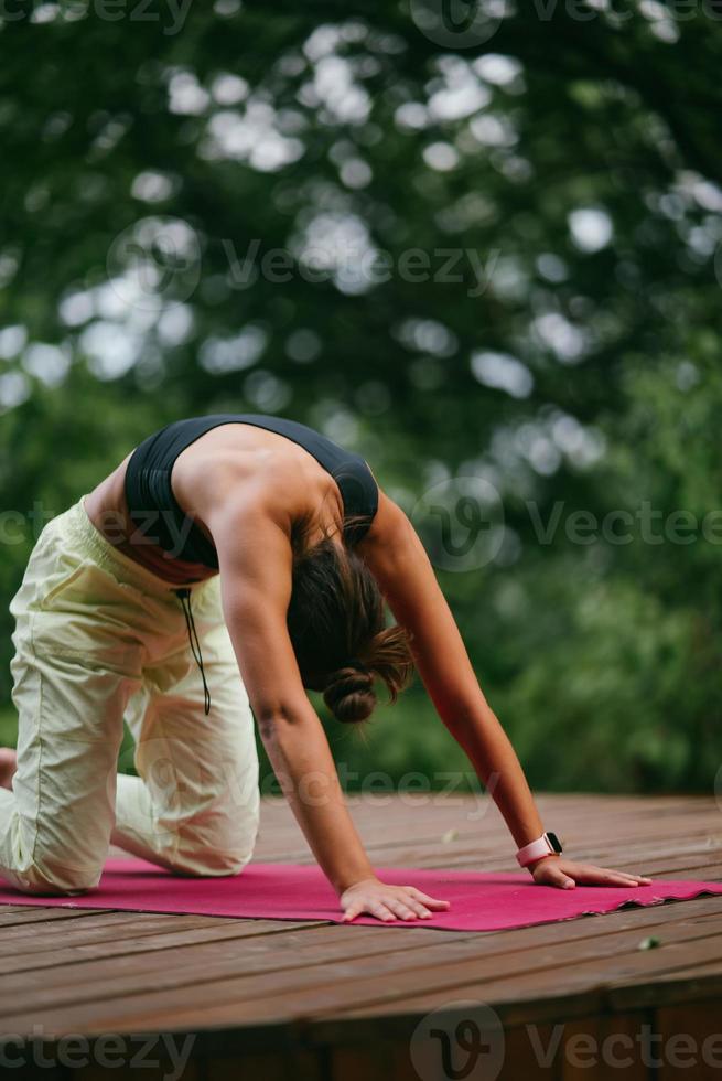 een jong vrouw in aan het doen yoga in de werf foto
