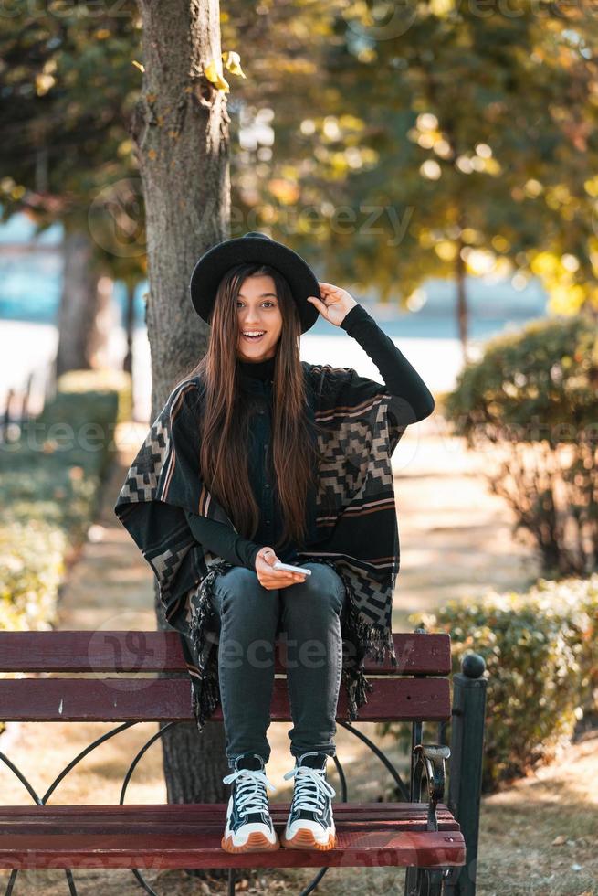 jong vrouw Aan een bank in de herfst park foto