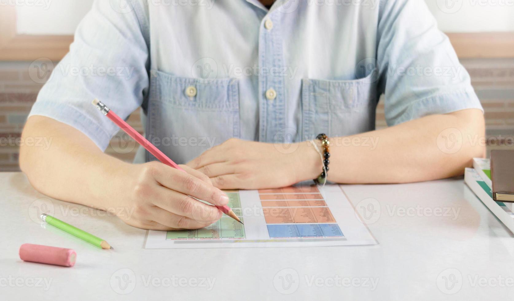 hand- Holding potlood over- Engels vel Aan bureau foto