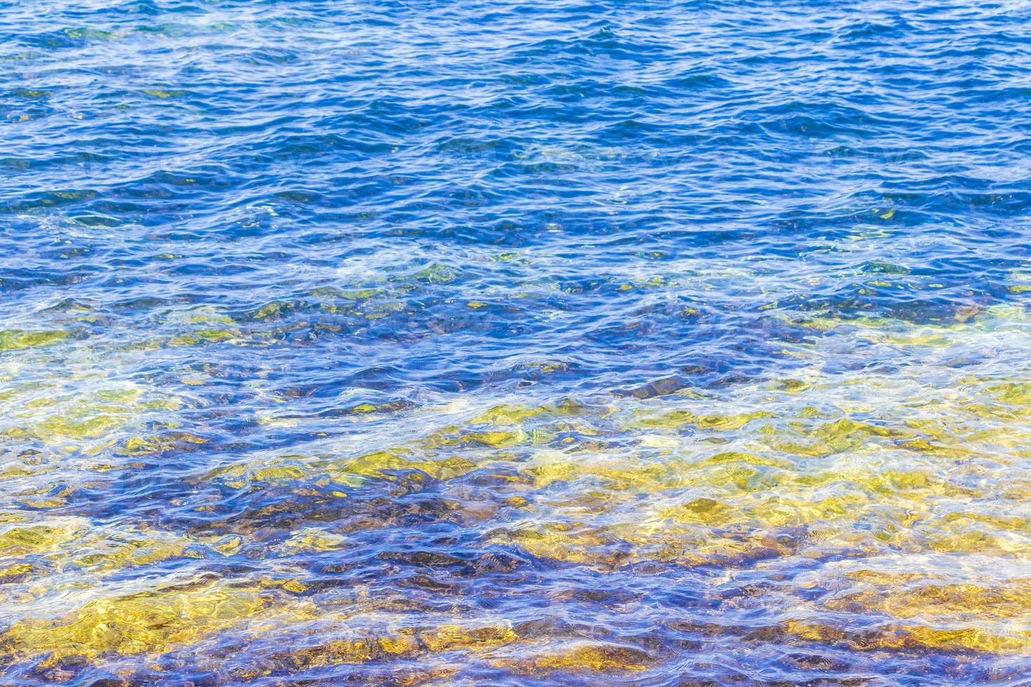 strand en kleurrijk turkoois blauw water structuur voula vouliagmeni Griekenland. foto
