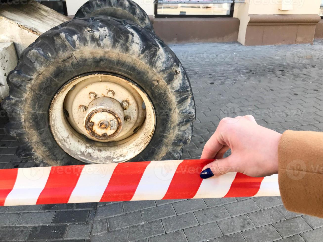 krachtig groot wielen met betreden en banden van van de weg af bouw apparatuur, tractoren, auto's tegen de achtergrond van beschermend rood en wit beschermend plakband foto