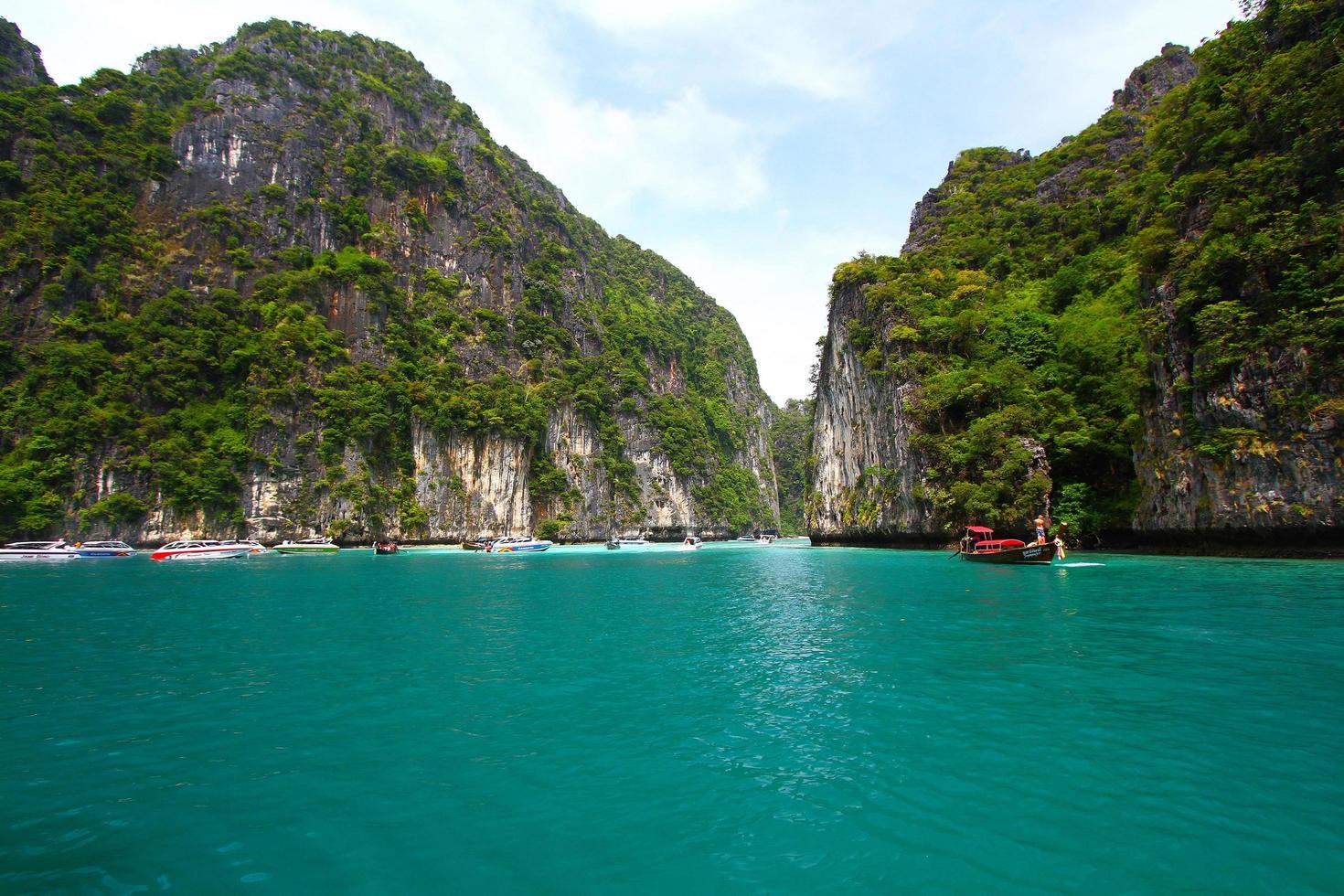 krabi, Thailand - december 5, 2020 veel snelheid boot geparkeerd of drijvend en hou op voor mensen, toerist, reiziger zwemmen en duiken Aan zee met groot rots berg achtergrond. werkzaamheid van groep tour. foto