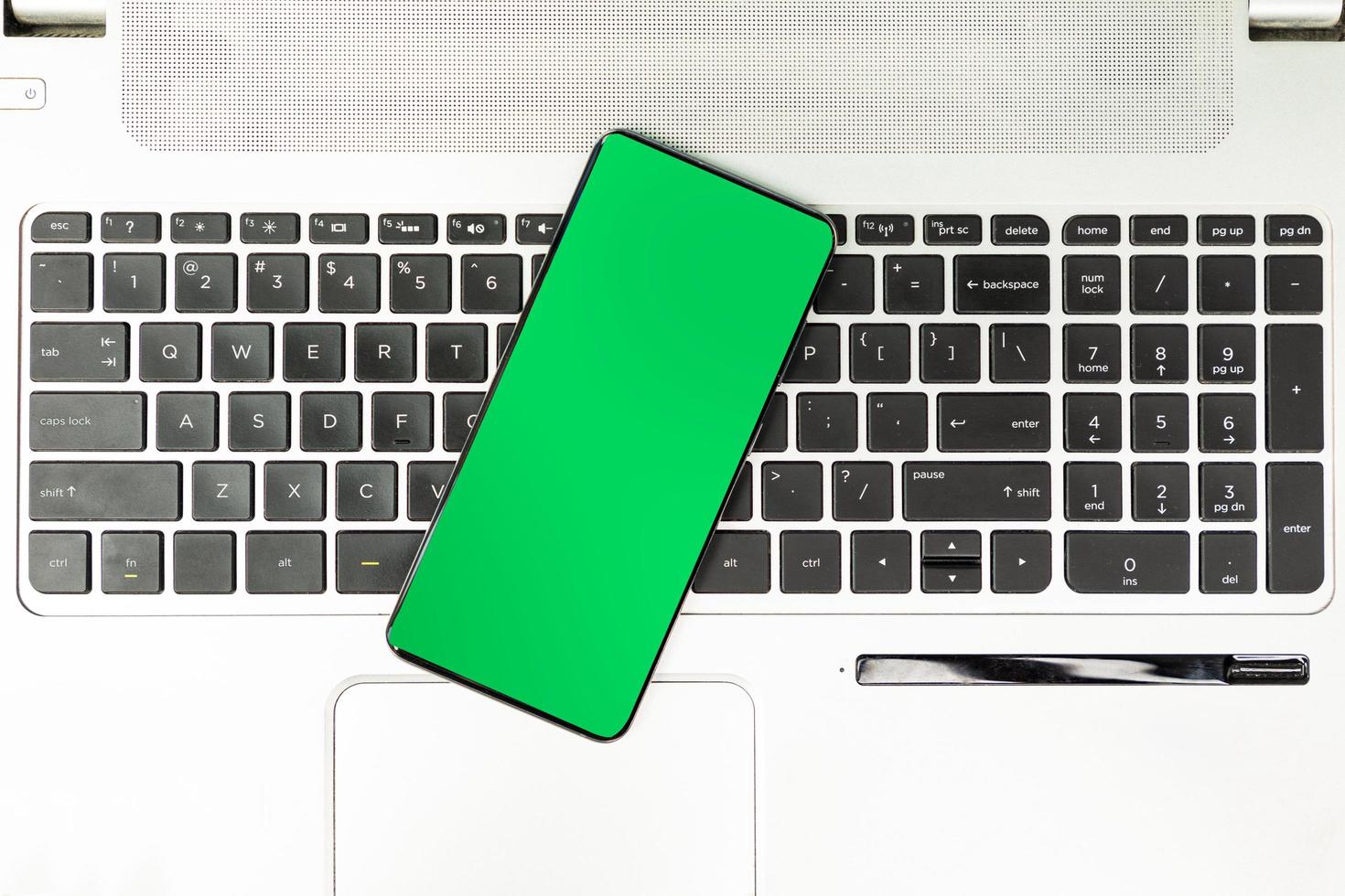 groen scherm smartphone op laptop toetsenbord foto