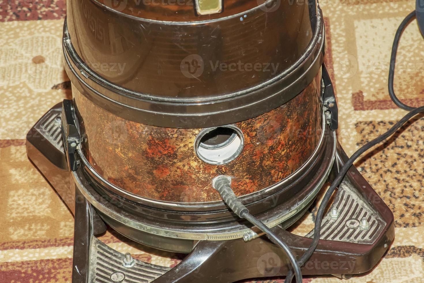 de werkwijze van schoonmaak de tapijt met een vacuüm schoonmaakster met een water filter. een vrouw hand- opent een gat voor blazen lucht in een vacuüm schoonmaakster foto