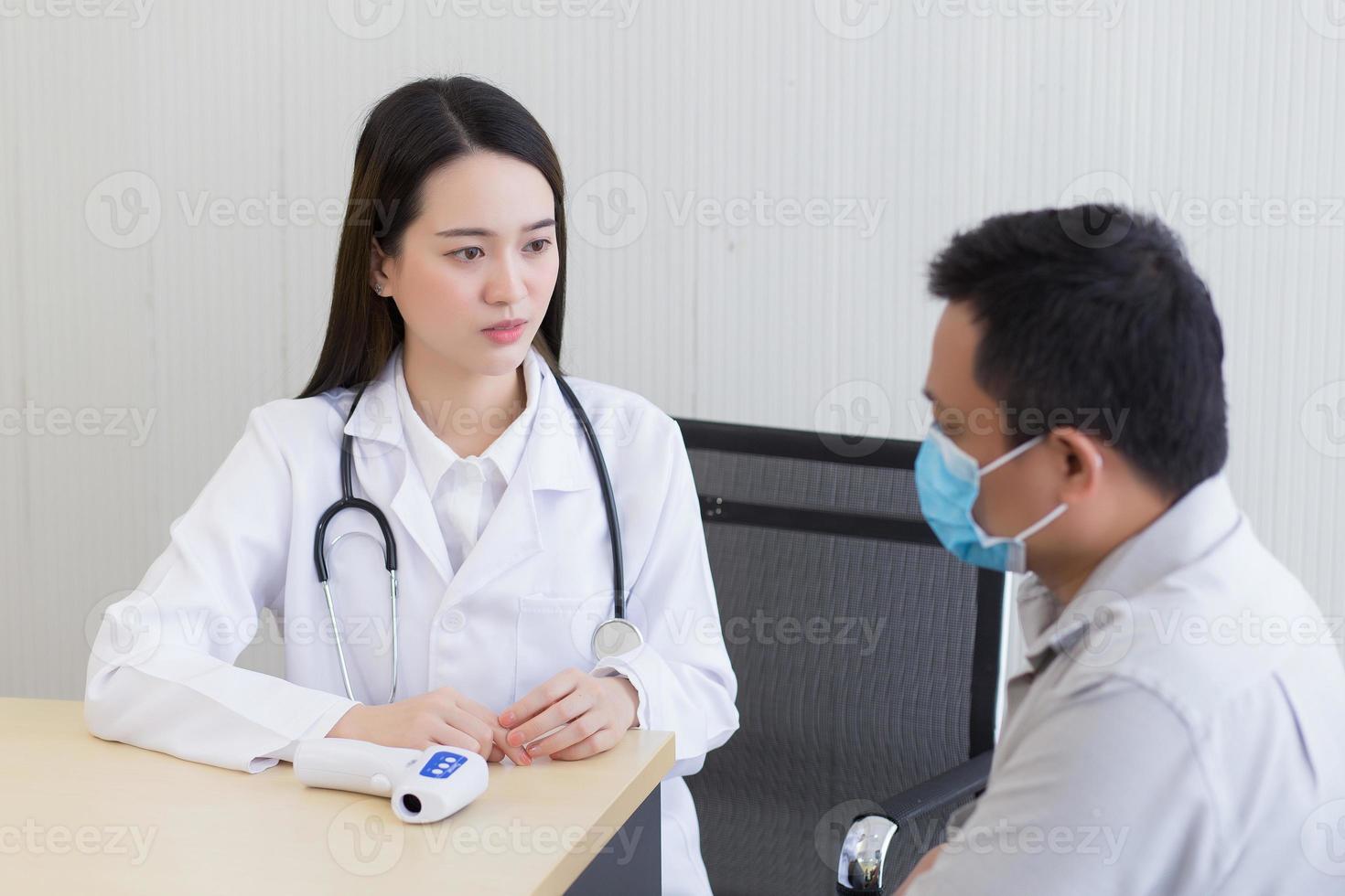 Aziatisch vrouw dokter met een wit laboratorium jas geven raad met een Mens geduldig foto