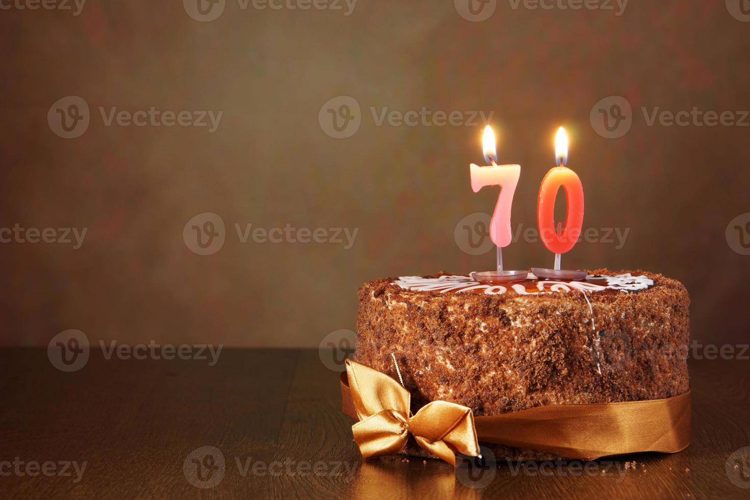 chocolade verjaardagstaart met brandende kaarsen als een nummer zeventig foto