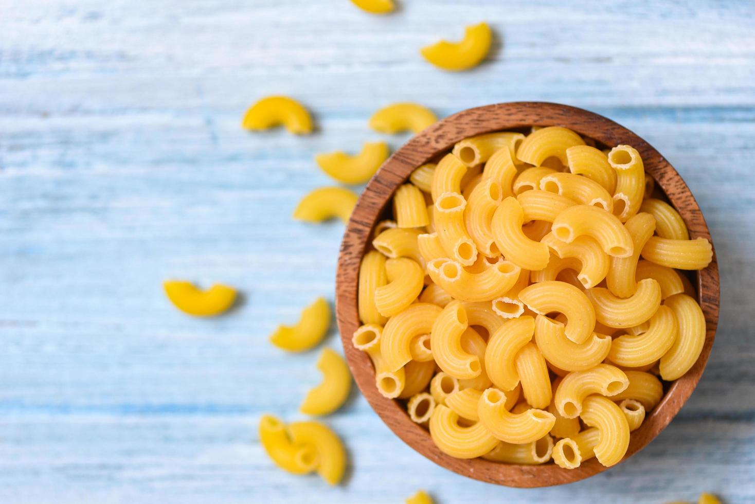 rauw macaroni ongekookt heerlijk pasta of penne noedels macaroni Aan houten kom achtergrond foto