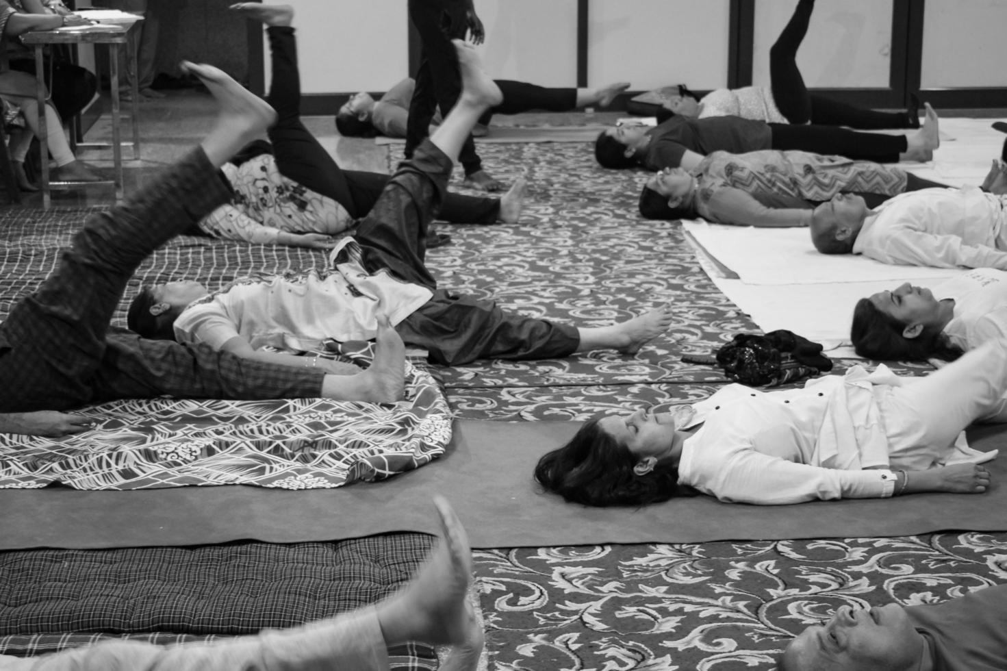 Delhi, Indië, juni 19 2022-groep yoga oefening sessie voor mensen van verschillend leeftijd groepen in balaj tempel, vivek vihar, Internationale yoga dag, groot groep van volwassenen Bijwonen yoga klasse-zwart en wit foto