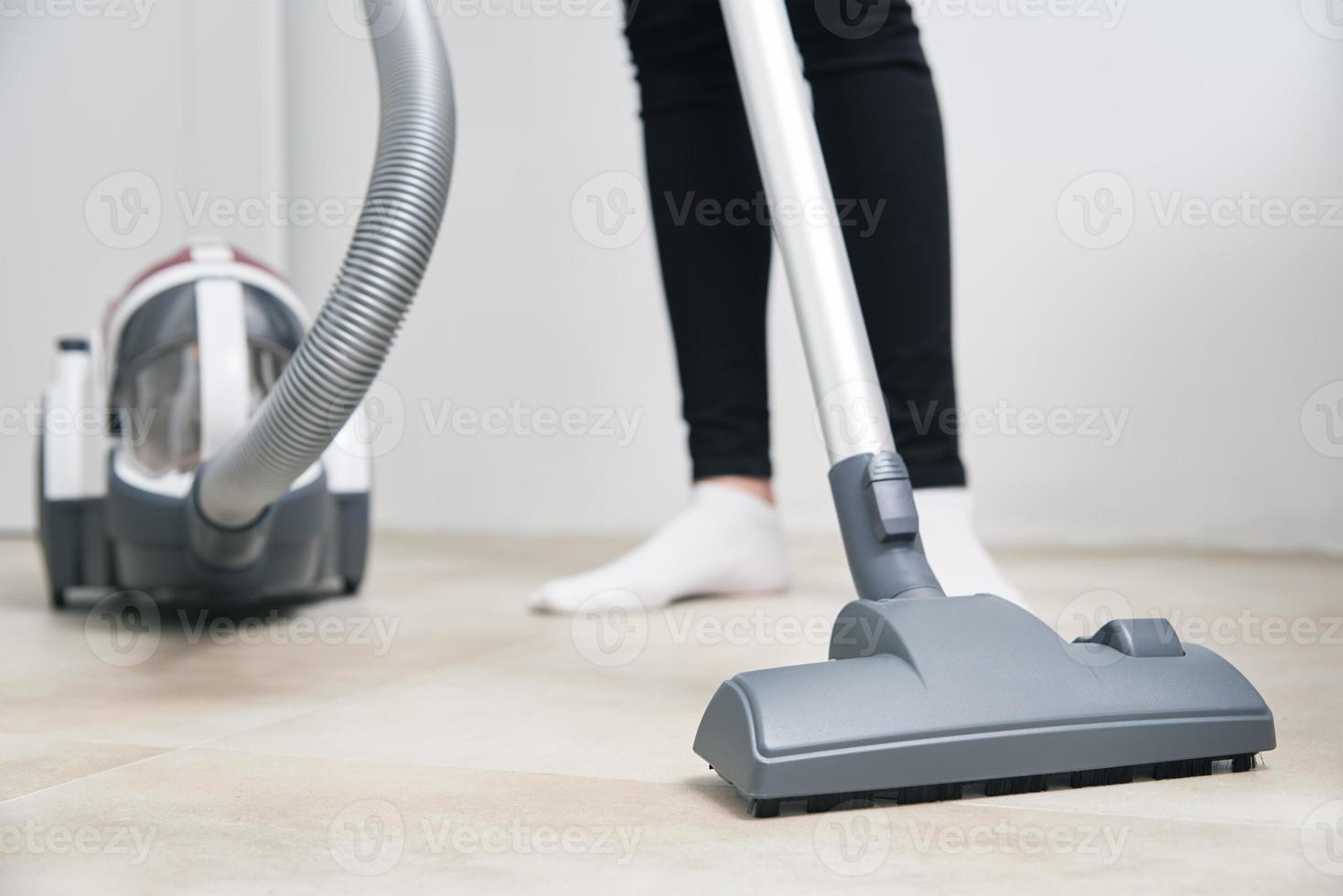 vrouw gebruik vacuüm schoonmaakster Bij de verdieping foto