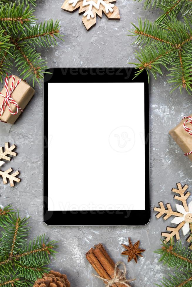 digitaal tablet bespotten omhoog met rustiek Kerstmis grijs cement achtergrond decoraties voor app presentatie. top visie met kopiëren ruimte foto