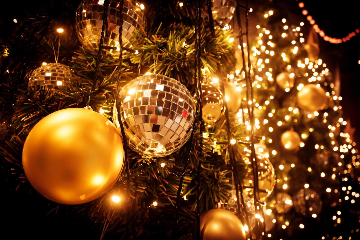 kerstboom met gouden bal en bokeh licht achtergrond foto