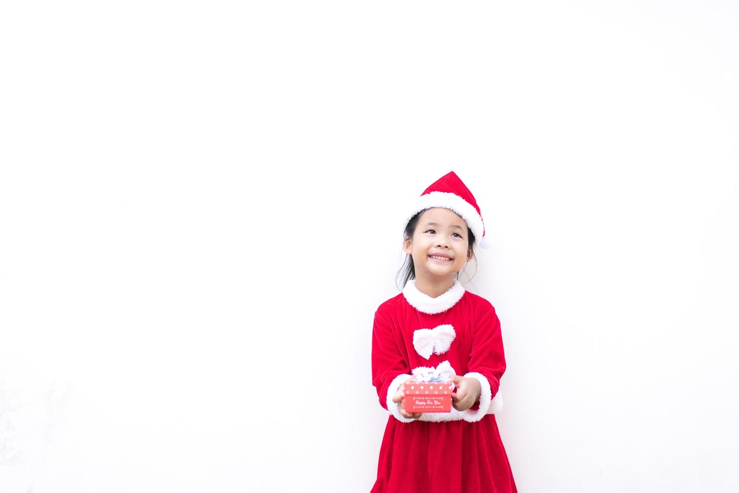 klein Aziatisch meisje in rood kerstman kostuum foto