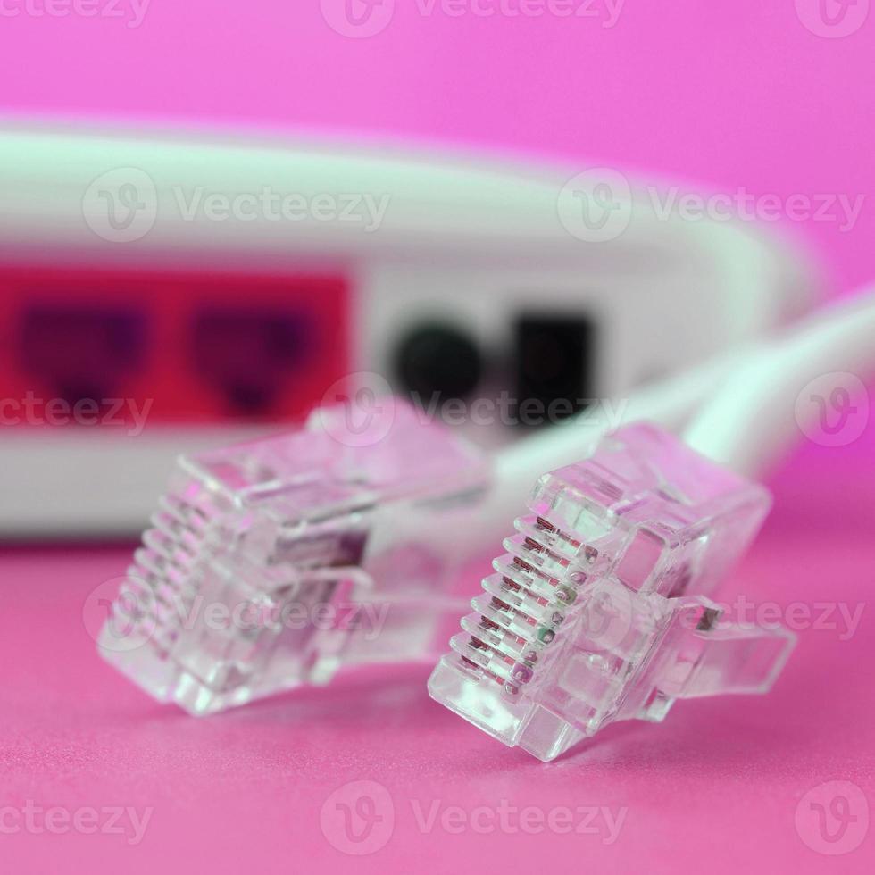 internet router en internet kabel pluggen liggen Aan een helder roze achtergrond. items verplicht voor internet foto