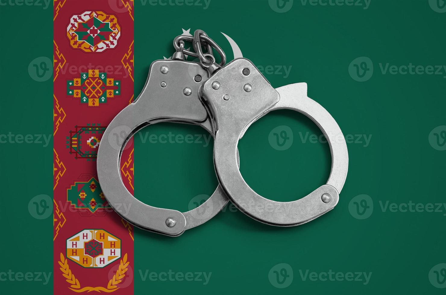 turkmenistan vlag en Politie handboeien. de concept van naleving van de wet in de land en bescherming van misdrijf foto