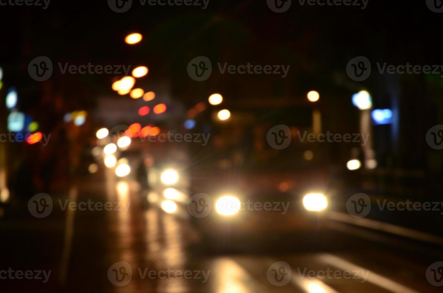 wazig nacht tafereel van verkeer Aan de rijweg. onscherp beeld van auto's op reis met lichtgevend koplampen. bokeh kunst foto