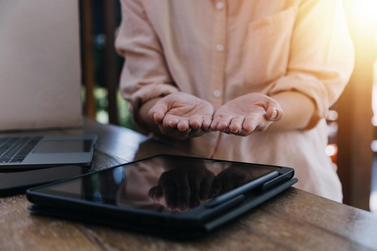 zakenvrouw hand werken met laptopcomputer, tablet en smartphone in modern kantoor met virtueel pictogram diagram op modernoffice in ochtendlicht foto