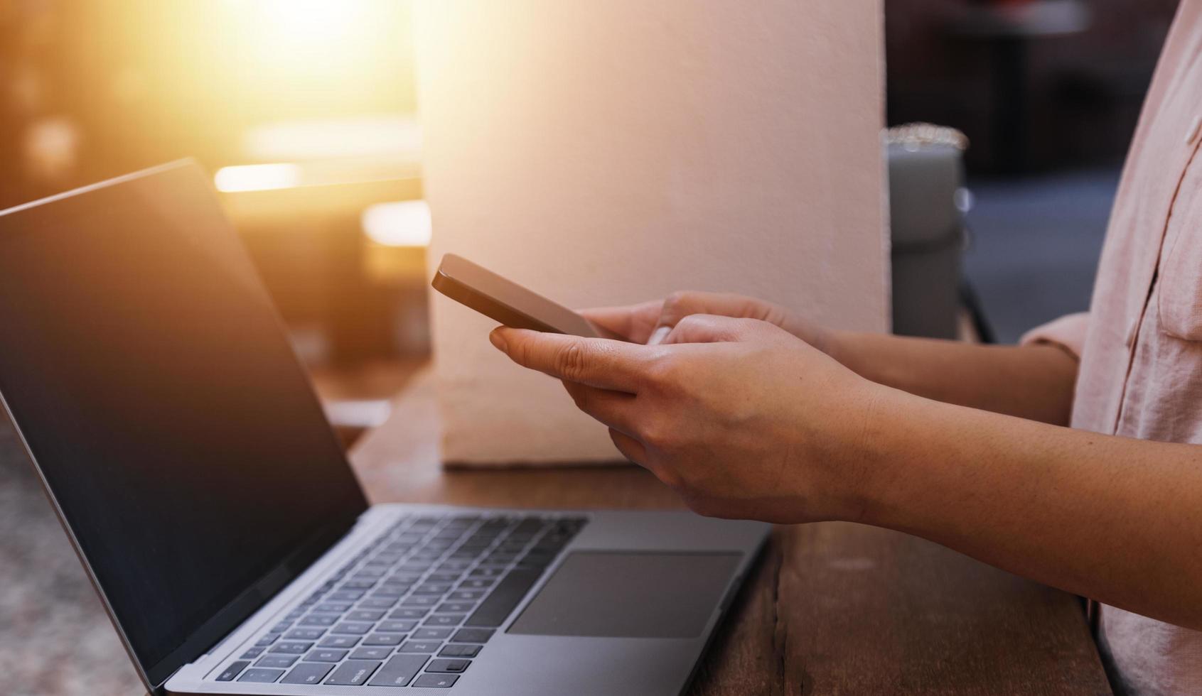 zakenvrouw hand werken met laptopcomputer, tablet en smartphone in modern kantoor met virtueel pictogram diagram op modernoffice in ochtendlicht foto