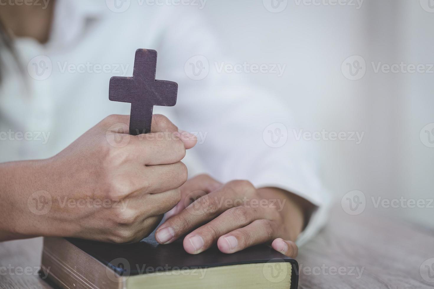 vrouw met kruis en Bijbel in handen bidden voor zegen van god in de ochtend, geestelijkheid en religie foto