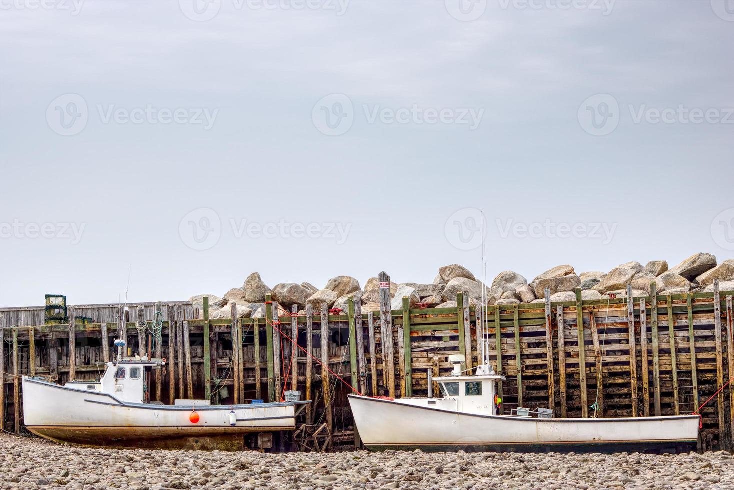 twee visvangst boten zittend Aan de bodem Bij laag tij in de baai van fundy foto