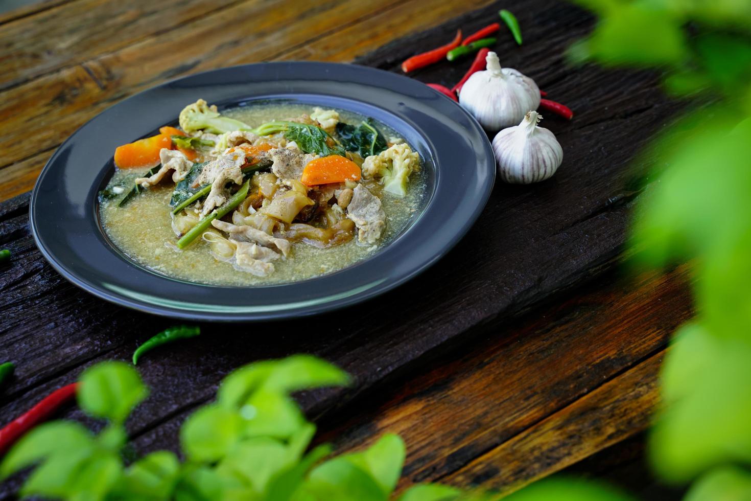 roeren gebakken noedels met varkensvlees en boerenkool in jus Chinese voedsel en Thais voedsel is populair naar eten allemaal over- de land. foto