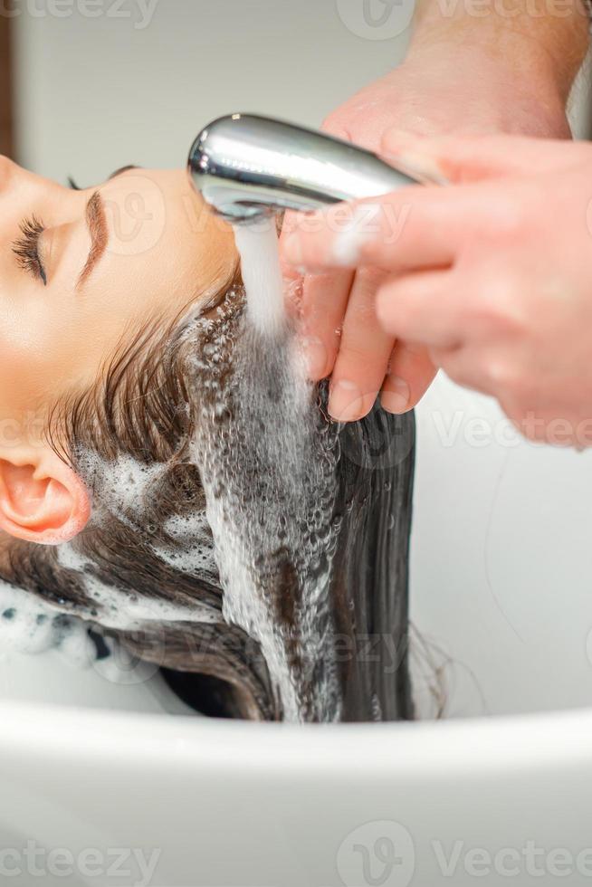 handen van kapper het wassen haar- van vrouw foto