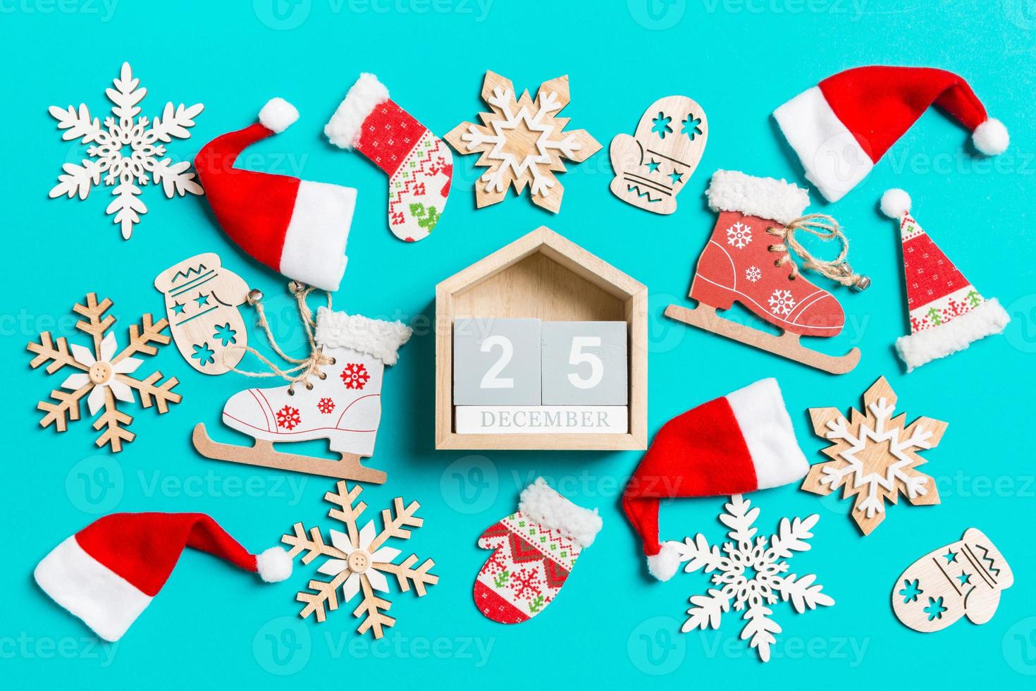 top visie van houten kalender met Kerstmis decoraties en de kerstman hoeden Aan blauw achtergrond. de twintig vijfde van december. gelukkig vakantie concept foto