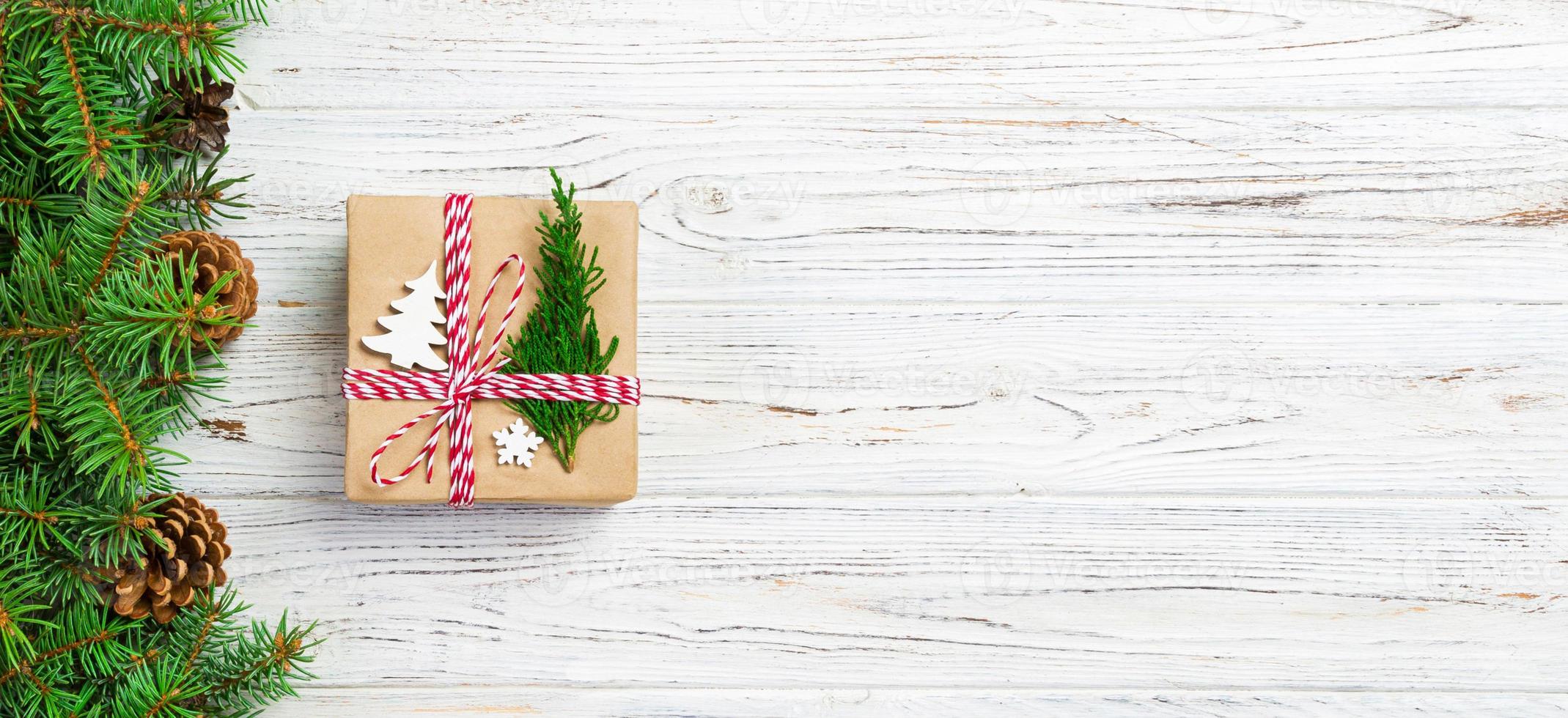 Kerstmis geschenk doos verpakt in gerecycled papier, met lint boog, met lint Aan rustiek achtergrond. vakantie banier concept foto