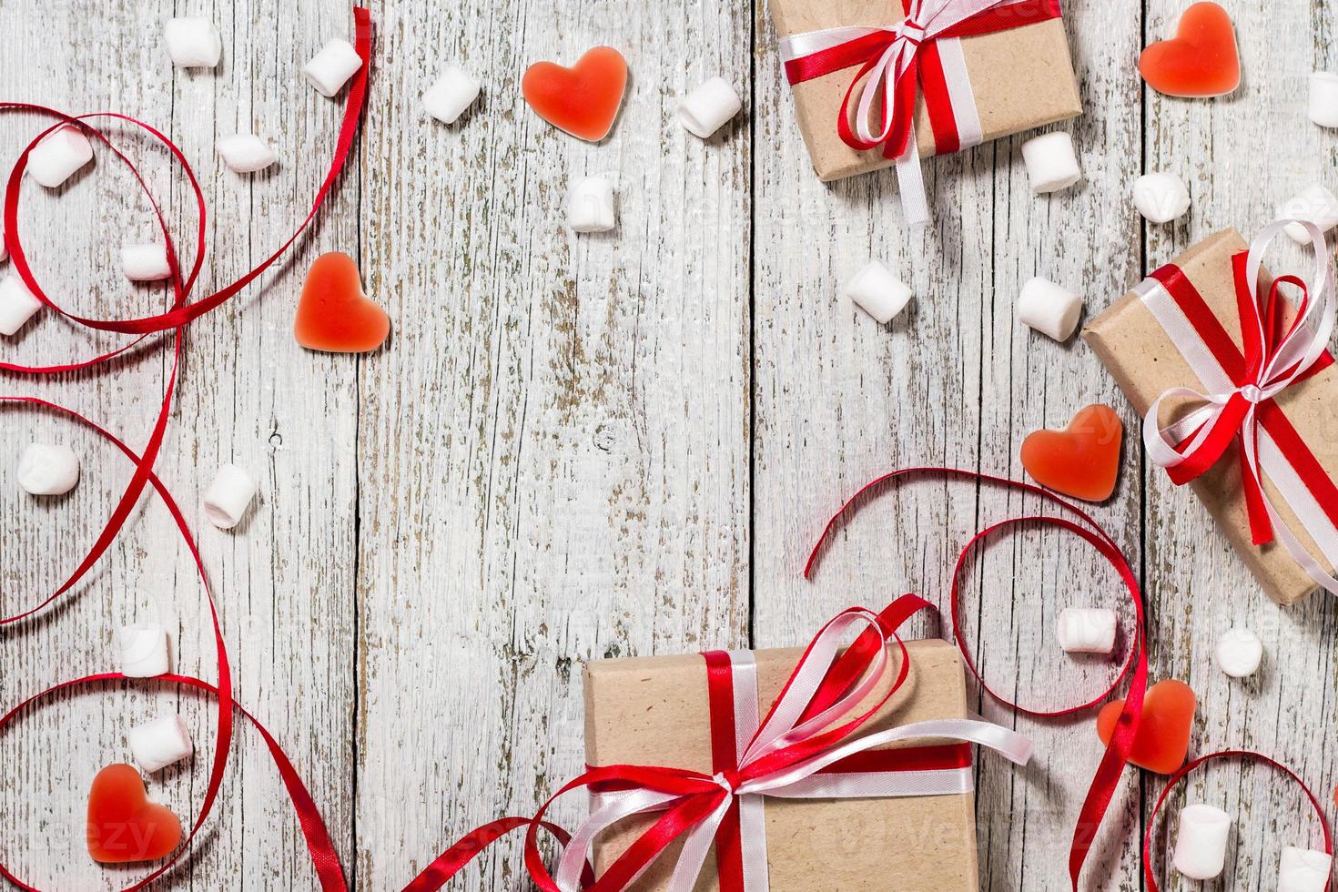 valentijnsdag dag snoep harten marshmallows en doos van cadeaus in ambacht papier over- wit houten achtergrond foto