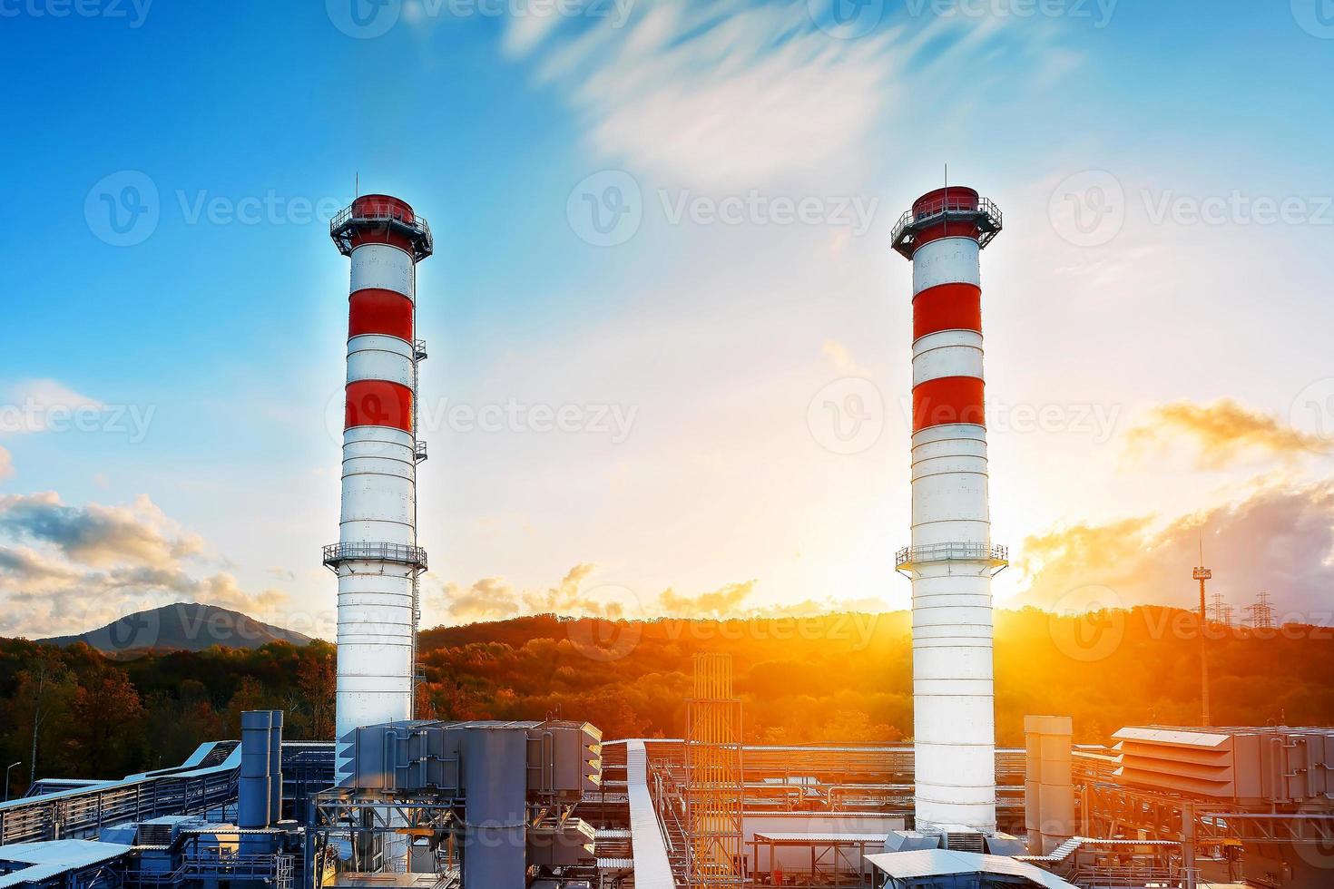 gas- macht fabriek met twee lang pijpen van wit kleur met rood poloskai Aan de achtergrond van bergen en zonsopkomst in een pittoreske milieuvriendelijk schoon plaats. foto