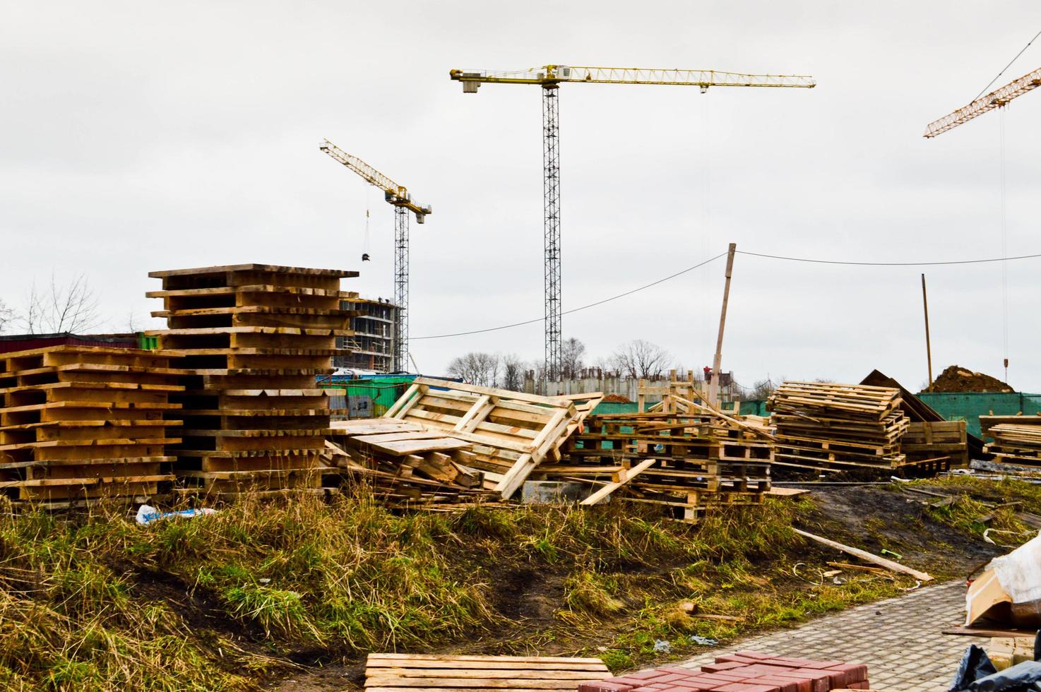 een groot modern bouw plaats in de bouw van gebouwen en huizen met huishoudelijke apparaten en veel groot hoog toren en stationair industrieel krachtig kranen en gebouw materialen foto