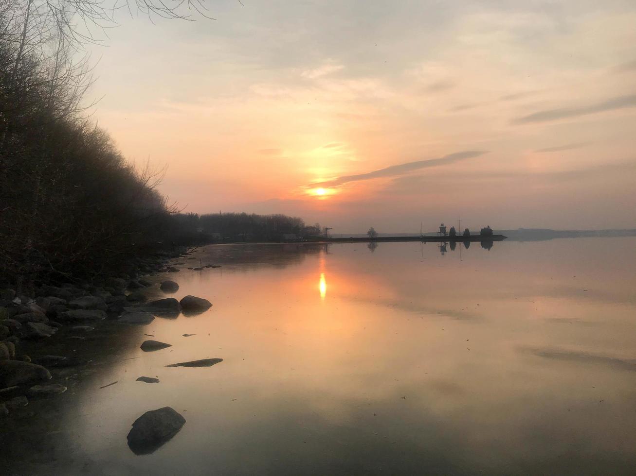 mooi rood zonsondergang over- de horizon van de water in de rivier, zee, oceaan, meer foto