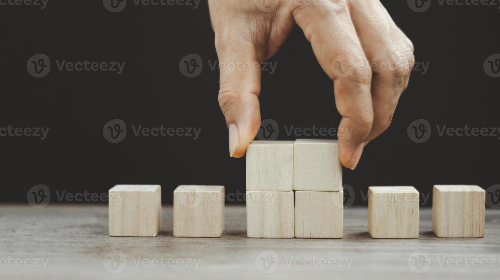 hand- regelen van hout blok stapelen net zo stap trap Aan houten tafel. bedrijf concept voor groei succes werkwijze. kopiëren ruimte foto