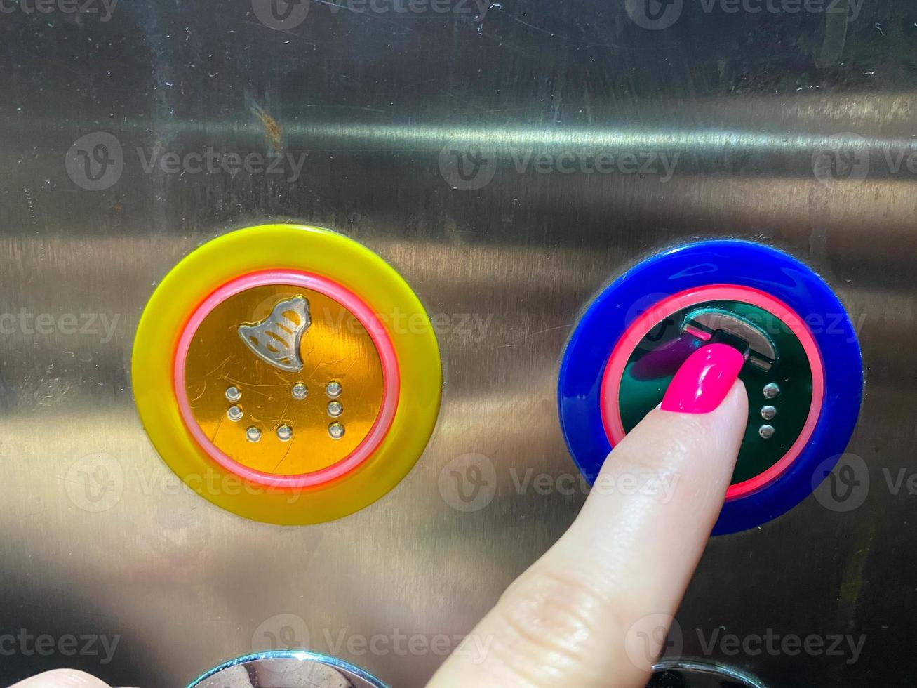 een vrouw gemanicuurd vinger Aan haar hand- persen een knop in een modern mooi lift in een hoogbouw gebouw foto