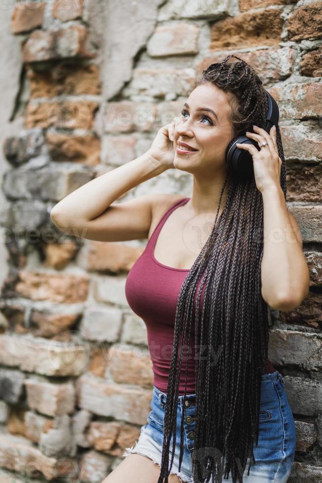 volleybal Verschrikkelijk Uitvoeren vrouw met lang afro gevlochten haar- luisteren muziek- van een  hoofdtelefoons buitenshuis 13875176 stockfoto bij Vecteezy