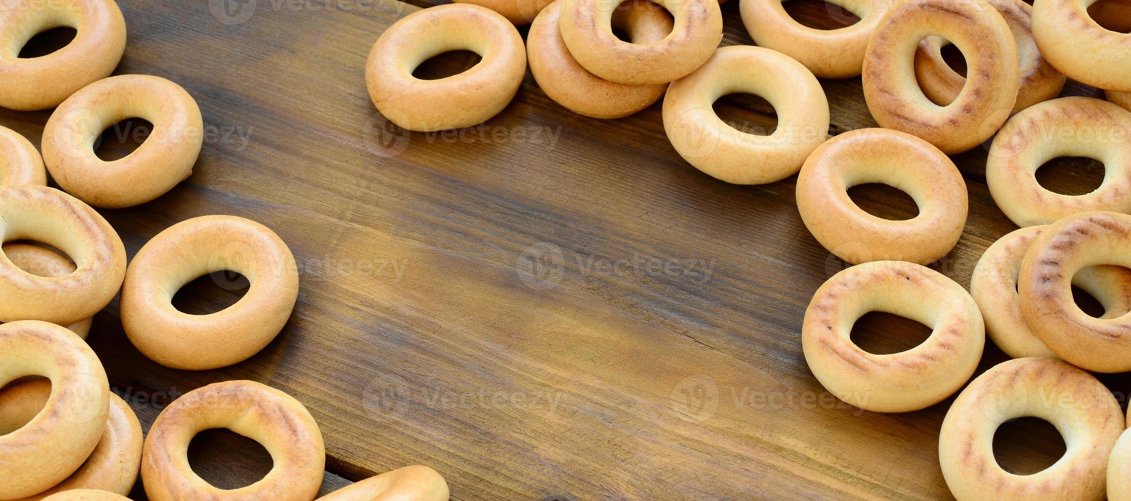 een veel van vers geel bagels liggen Aan de oppervlakte van de oud donker hout. een populair soort van meel producten. een van de traditioneel Russisch behandelt voor thee foto