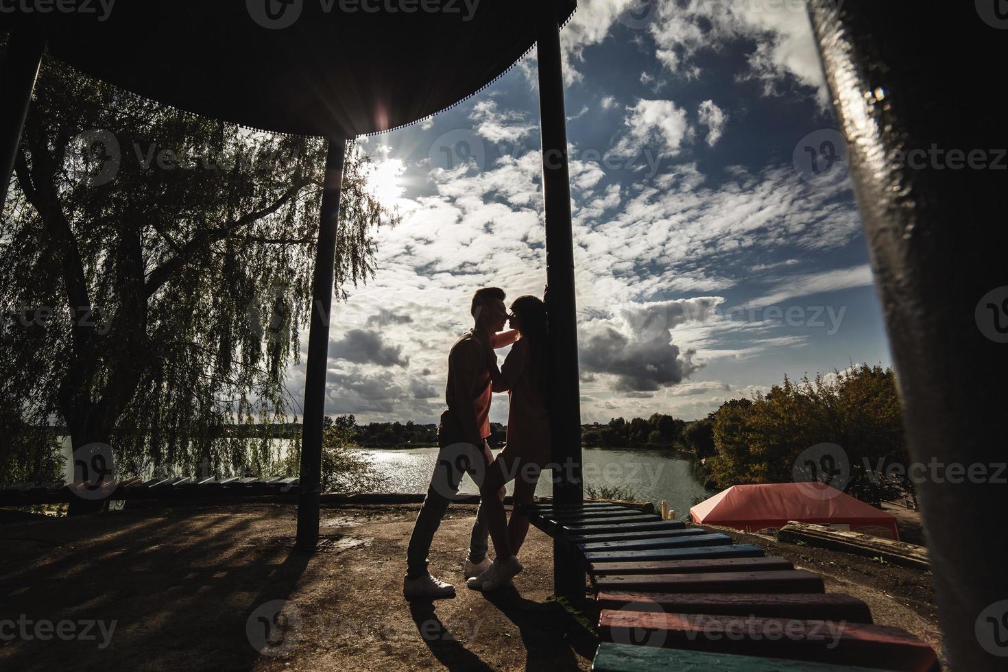 silhouet van liefhebbend jong paar is hebben pret buitenshuis. liefde en tederheid, daten, romantiek, familie concept foto