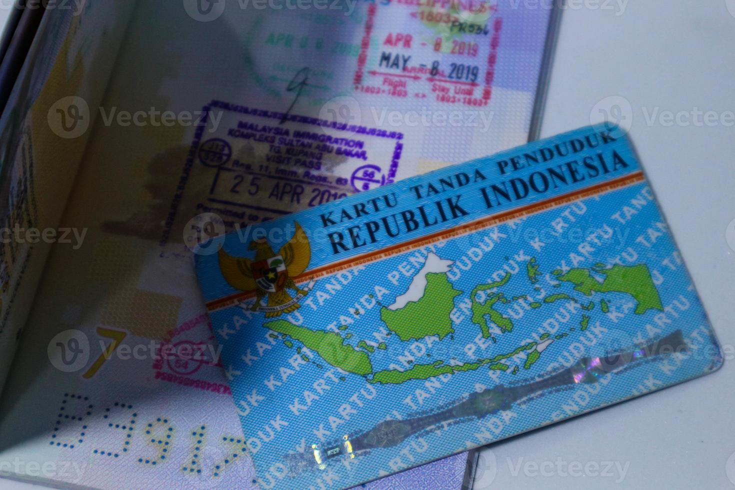 Maleisisch en Filipijns immigratie postzegels in de Indonesisch groen paspoort en Indonesisch identiteit kaart. foto