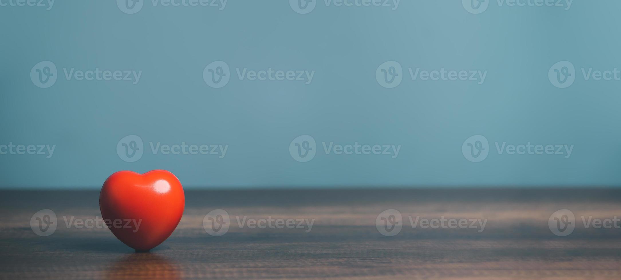 een rood hart voor liefde zetten Aan de tafel, Gezondheid zorg, orgaan bijdrage, wereld hart dag, wereld Gezondheid dag, opmerkzaamheid, goed het zijn, familie verzekering concept. foto