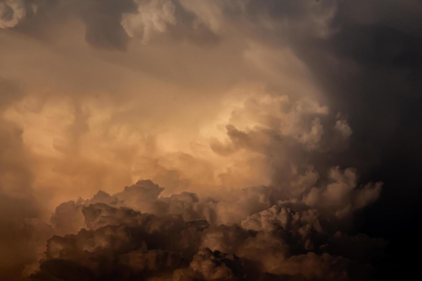 een oranje wolk gevormd een regen wolk een avond foto